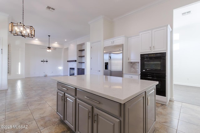 kitchen with gray cabinetry, ceiling fan with notable chandelier, double oven, stainless steel built in fridge, and white cabinets