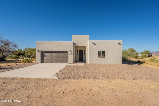 pueblo revival-style home with a garage