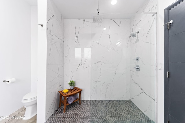 bathroom with tile patterned flooring, a tile shower, and toilet