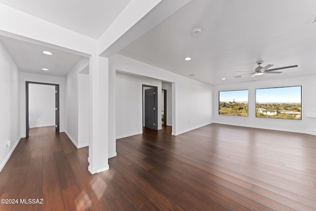 unfurnished living room featuring dark hardwood / wood-style flooring and ceiling fan