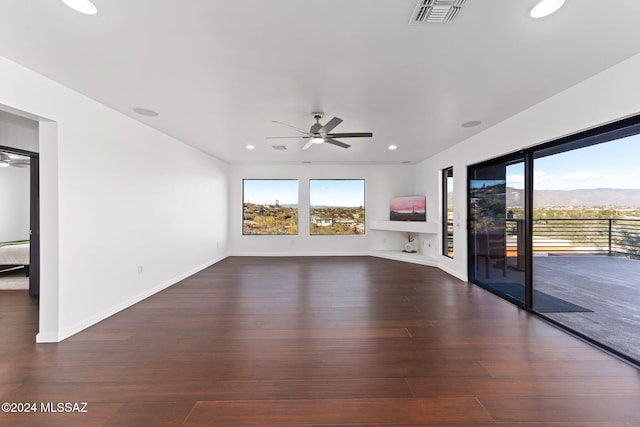 unfurnished living room with ceiling fan and dark hardwood / wood-style flooring