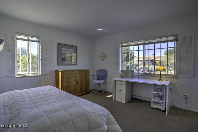 carpeted bedroom with brick wall