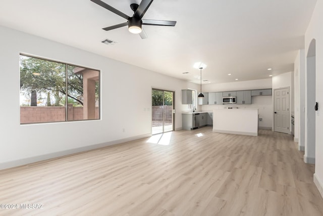 unfurnished living room featuring ceiling fan and light hardwood / wood-style floors