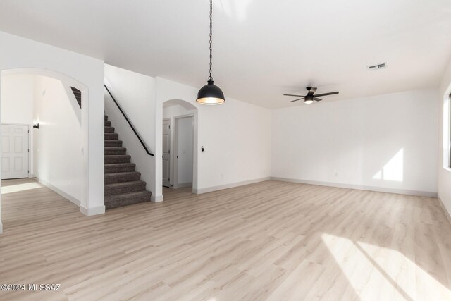 unfurnished living room featuring light wood-type flooring and ceiling fan