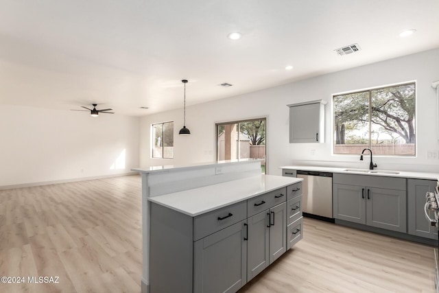 kitchen featuring sink, stainless steel dishwasher, ceiling fan, gray cabinets, and decorative light fixtures