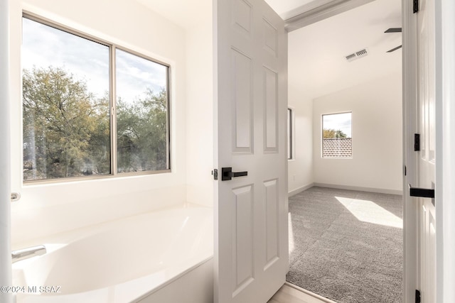 bathroom featuring a tub and lofted ceiling