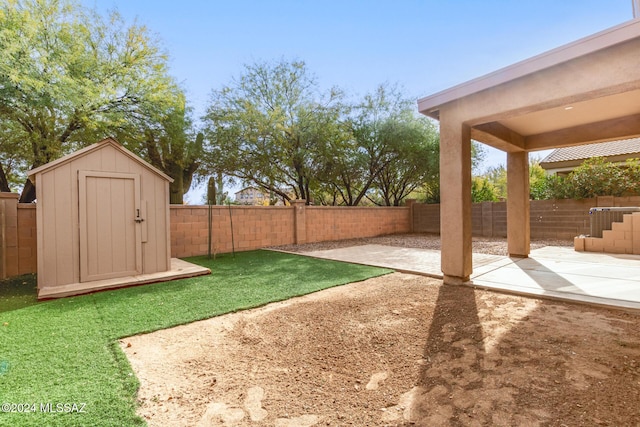 view of yard featuring a storage shed and a patio area