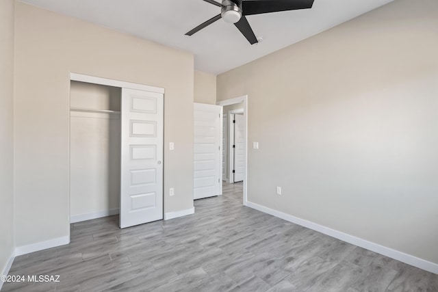 unfurnished bedroom featuring ceiling fan, a closet, and light wood-type flooring