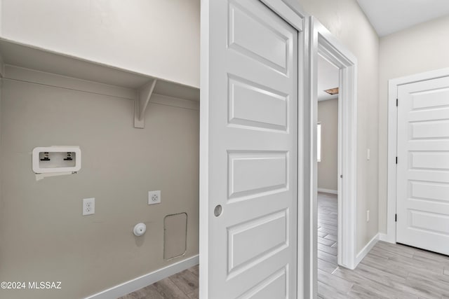 clothes washing area featuring washer hookup, electric dryer hookup, and light hardwood / wood-style flooring