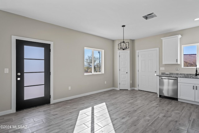 kitchen featuring sink, light hardwood / wood-style flooring, stainless steel dishwasher, light stone counters, and white cabinetry