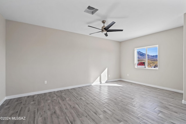 spare room with ceiling fan and light wood-type flooring