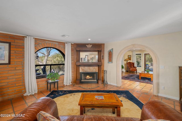 tiled living room with a fireplace and a healthy amount of sunlight