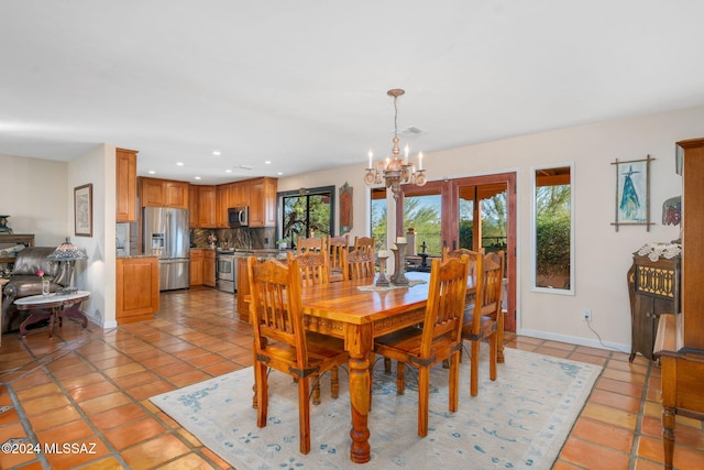 dining space with light tile patterned floors and an inviting chandelier