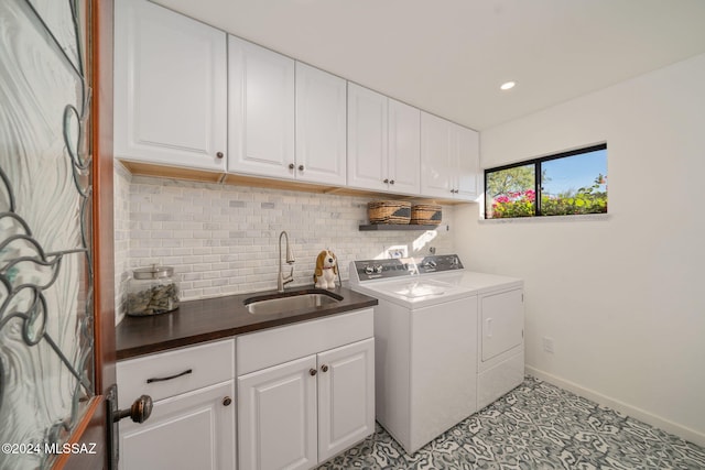 clothes washing area featuring cabinets, light tile patterned floors, washer and clothes dryer, and sink