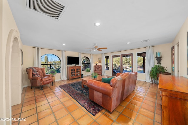 tiled living room with ceiling fan and french doors