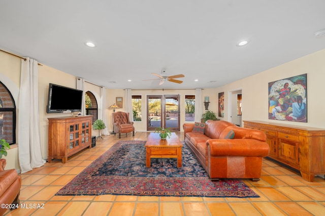 tiled living room with ceiling fan and french doors