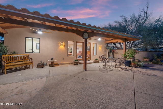 patio terrace at dusk featuring ceiling fan