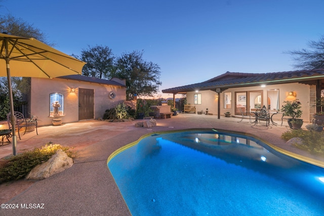 pool at dusk featuring a patio