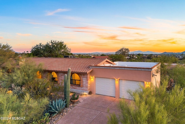 view of front of home with a mountain view and a garage