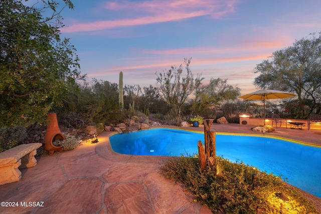 pool at dusk with a patio