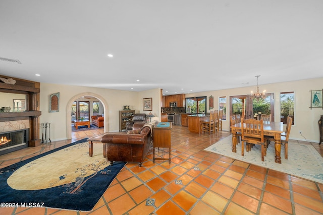 tiled living room with a chandelier and a large fireplace