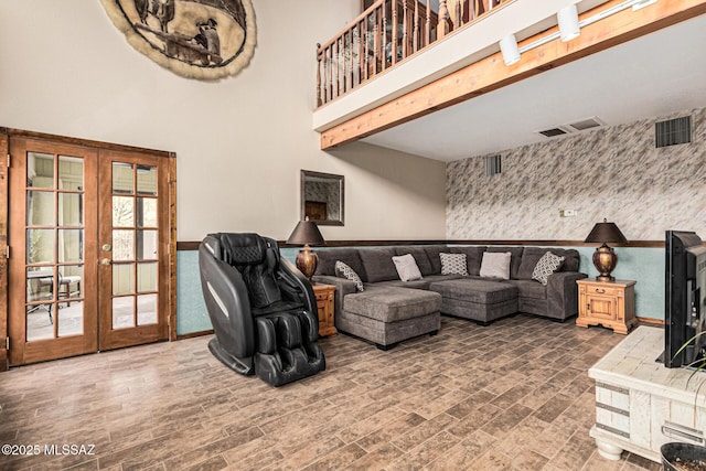 living room featuring french doors, a towering ceiling, and dark hardwood / wood-style flooring