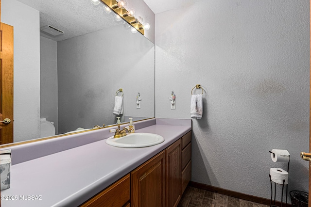 bathroom featuring vanity, hardwood / wood-style floors, and a textured ceiling