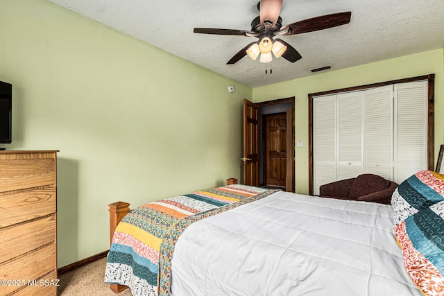 bedroom featuring ceiling fan, carpet floors, a textured ceiling, and a closet