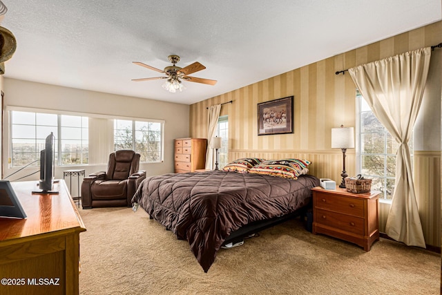 bedroom with ceiling fan, a textured ceiling, and carpet flooring