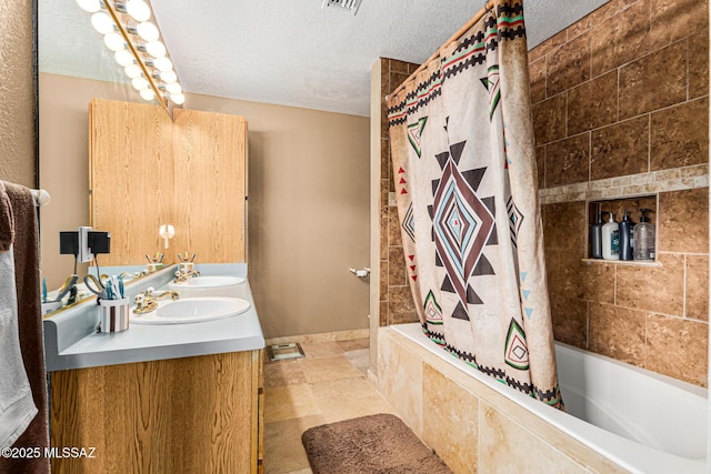 bathroom featuring vanity, shower / bath combo, and a textured ceiling