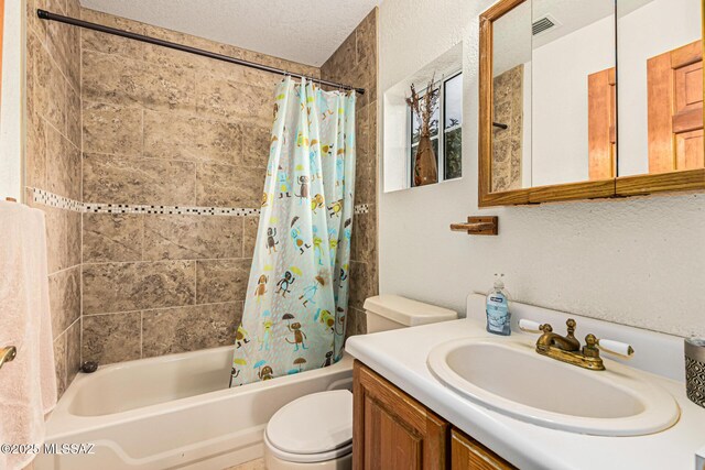 full bathroom featuring vanity, shower / tub combo, a textured ceiling, and toilet