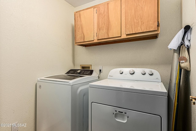 laundry room featuring washing machine and dryer and cabinets