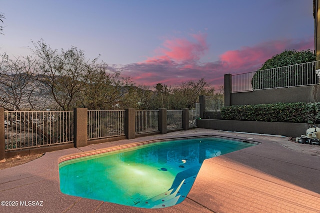 pool at dusk with a patio area