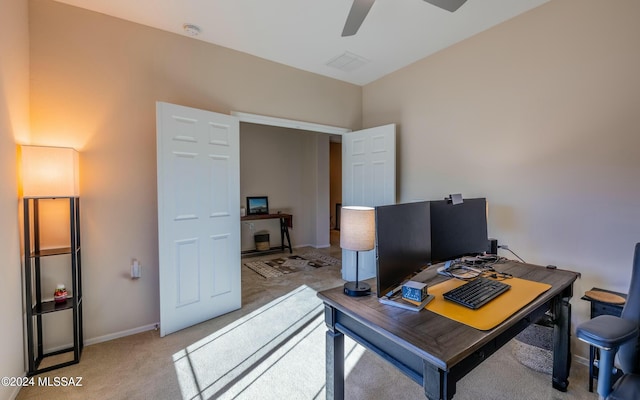 carpeted home office featuring ceiling fan