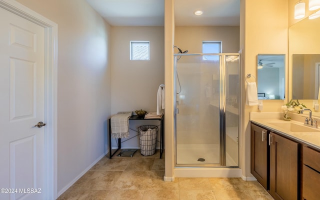 bathroom with vanity, a shower with door, a wealth of natural light, and ceiling fan