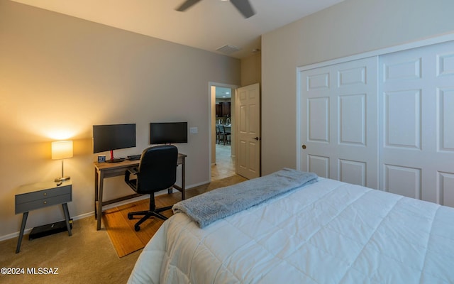 bedroom with ceiling fan, a closet, and light colored carpet