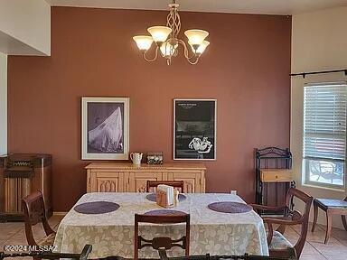 dining space with light tile patterned floors and a chandelier