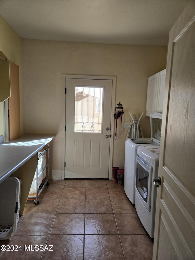 laundry room featuring dark tile patterned flooring, cabinets, and independent washer and dryer