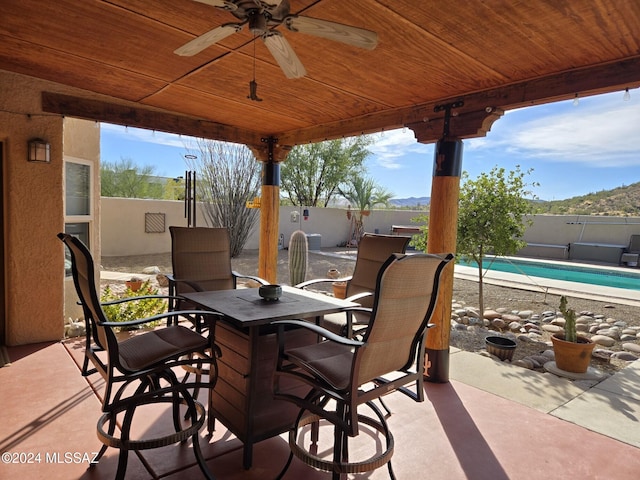 view of patio featuring ceiling fan and a fenced in pool