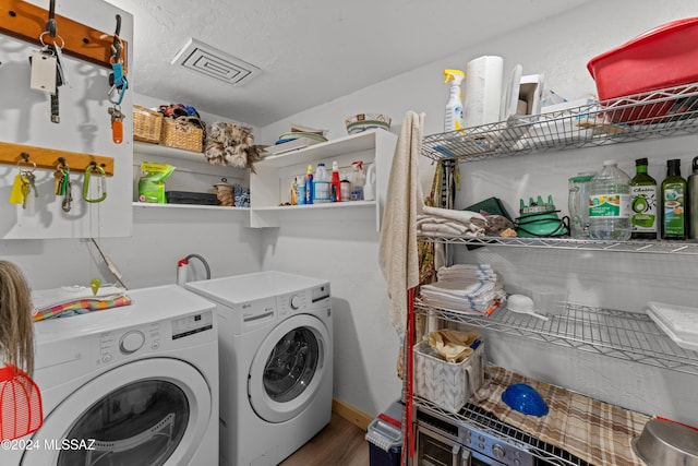 clothes washing area featuring independent washer and dryer and wood-type flooring