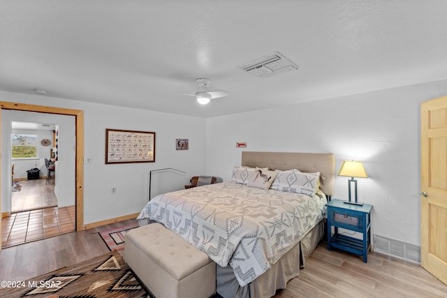 bedroom with light hardwood / wood-style floors and ceiling fan