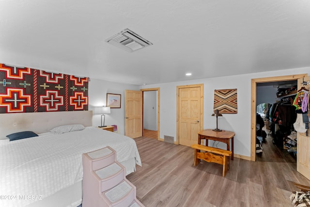 bedroom featuring hardwood / wood-style floors and a spacious closet