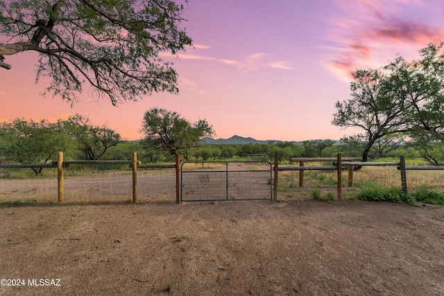 yard at dusk with a mountain view and a rural view