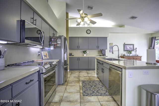 kitchen featuring ceiling fan, sink, lofted ceiling, light tile patterned floors, and appliances with stainless steel finishes