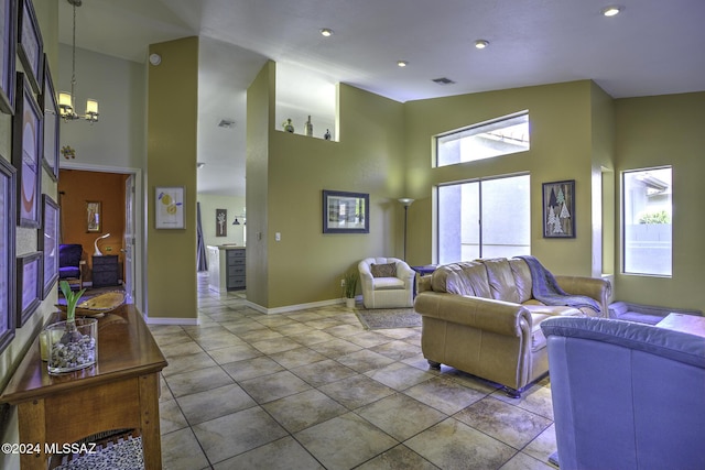 living room featuring tile patterned floors, an inviting chandelier, and high vaulted ceiling