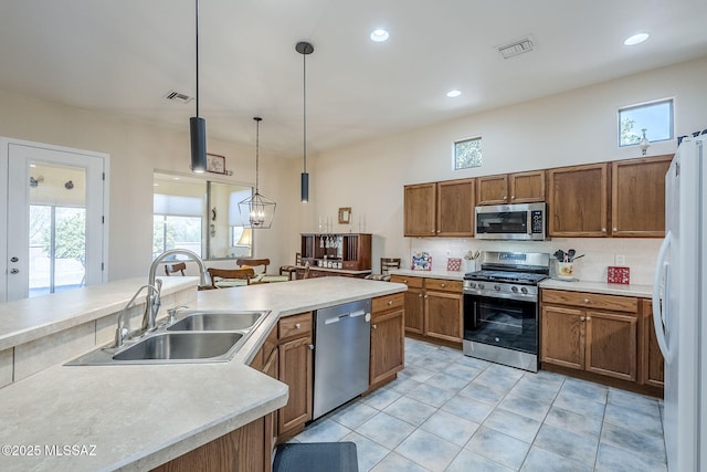 kitchen with hanging light fixtures, a healthy amount of sunlight, appliances with stainless steel finishes, and sink