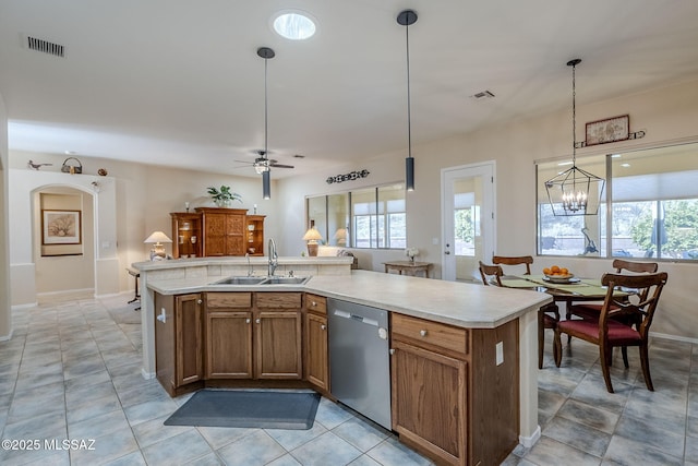 kitchen with dishwasher, sink, hanging light fixtures, a healthy amount of sunlight, and a center island with sink