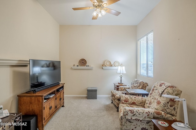 living area featuring light carpet and ceiling fan