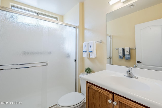 bathroom featuring vanity, toilet, and an enclosed shower