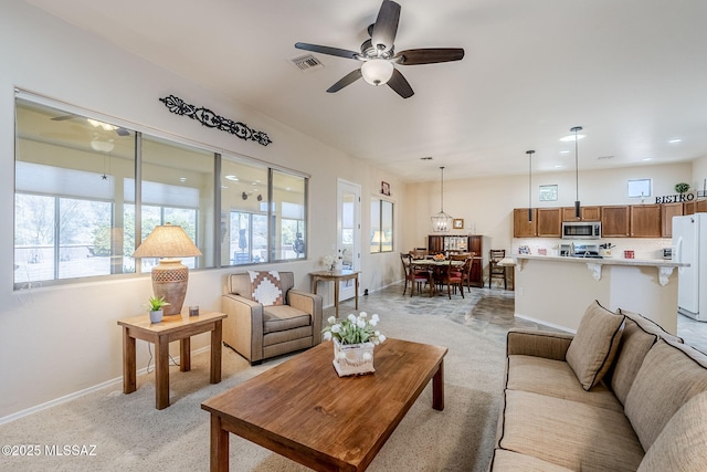 carpeted living room with ceiling fan